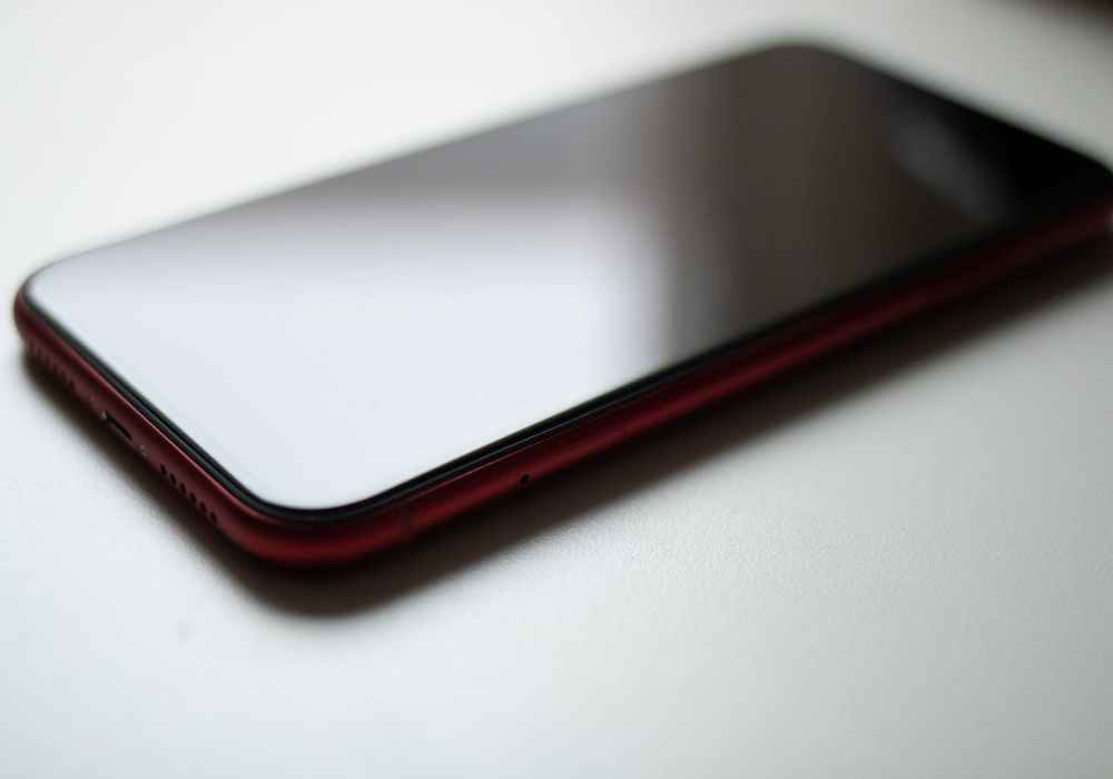 red smartphone on white desk