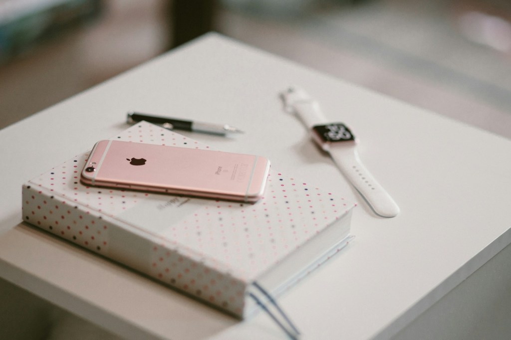 desk with book, Apple Watch and iPhone